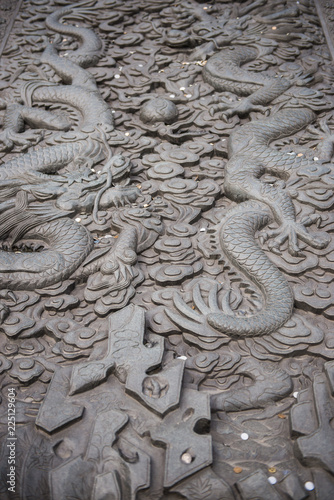 Old dragon sculpture with many coins to prepare for the merit at jing'an temple in shanghai, china.