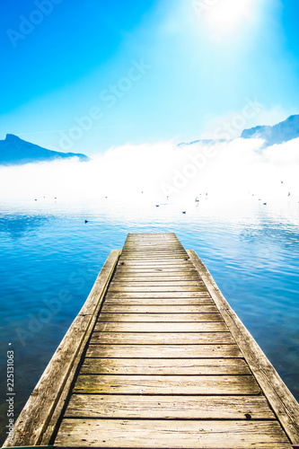 Morning fog on Pier of lake Mondsee and Alps in Austria
