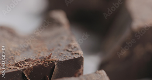 closeup breaking dark chocolate block with knife