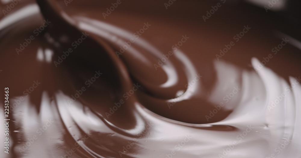 closeup stirring molten dark chocolate with spoon closeup stirring molten dark chocolate with spoon