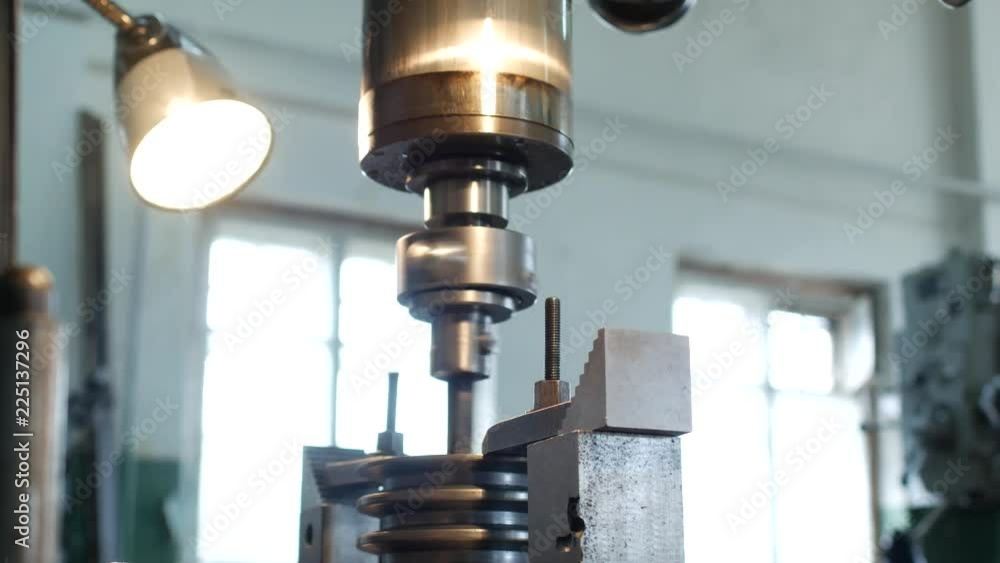 A drilling machine drills a hole in a metal pulley, an industry, a pulley for machinery, a small business, an industry, tool A drilling machine drills a hole in a metal pulley, an industry, a pulley for machinery, a small business, an industry, tool