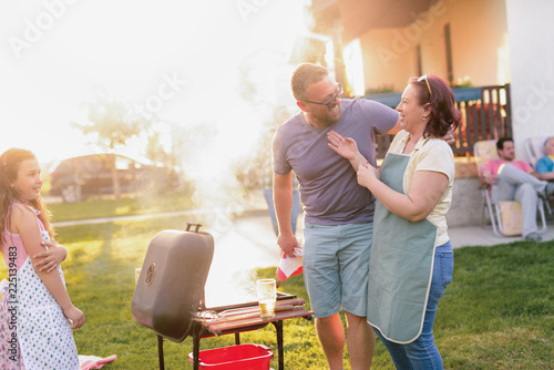 Picture of middle age couple making barbeque in their backyard. Family lunch on summer day. photo