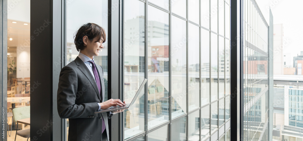 ノートパソコンを持つ男性