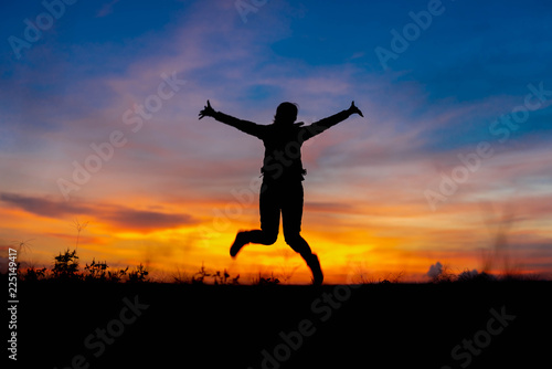 Silhouette woman jumping happily relieved.