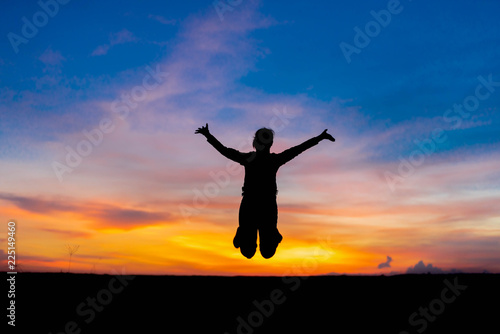 Silhouette woman jumping happily relieved.