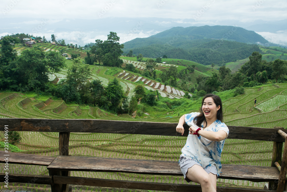 Naklejka premium The pretty woman relaxing in holiday at rice terrace, Rice planting season in Chiang Mai, Tourism concept