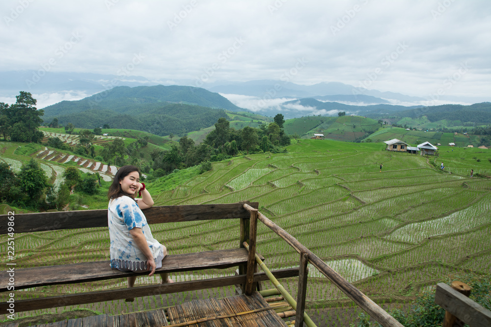 The pretty woman relaxing in holiday at rice terrace, Rice planting season in Chiang Mai, Tourism concept