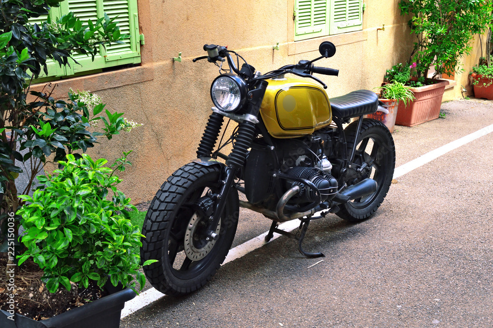 Moto ancienne stationnée dans une ruelle d'un petit village