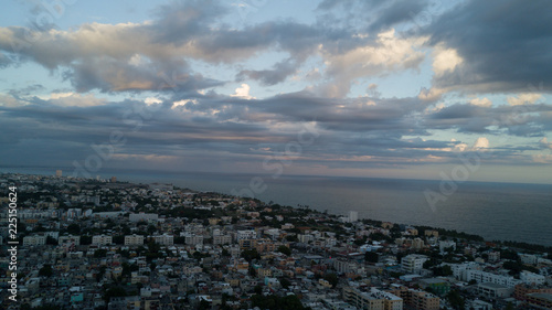 An aerial drone shoot captures the stunning coastal beauty of Santo Domingo, where the sparkling Caribbean Sea meets golden sandy shores. The footage highlights the dynamic contrast between the vibran
