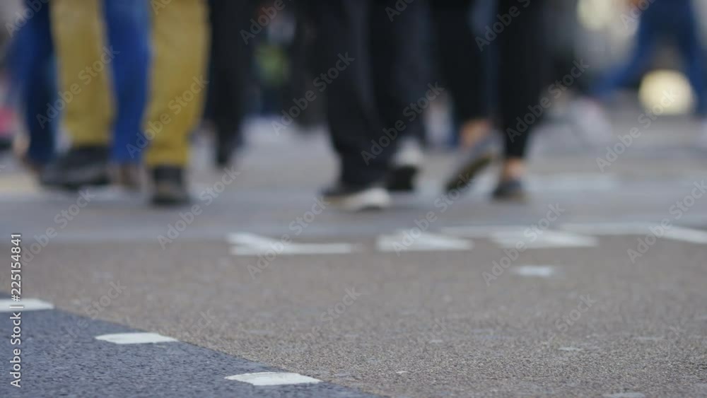 Low angle of commuters crossing a road, in slow motion Low angle of commuters crossing a road, in slow motion