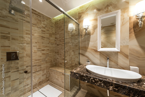 Luxury decorated bathroom, glass shower, sink and mirror
