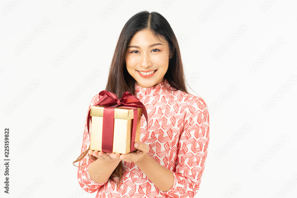 Photo of asian curious woman in red dress rejoicing her birthday or new year gift box. Young woman holding gift box with red bow being excited and surprised holiday present isolated white background Photo of asian curious woman in red dress rejoicing her birthday or new year gift box. Young woman holding gift box with red bow being excited and surprised holiday present isolated white background