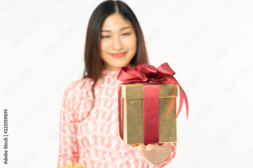 Photo of asian curious woman in red dress rejoicing her birthday or new year gift box. Young woman holding gift box with red bow being excited and surprised holiday present isolated white background Photo of asian curious woman in red dress rejoicing her birthday or new year gift box. Young woman holding gift box with red bow being excited and surprised holiday present isolated white background