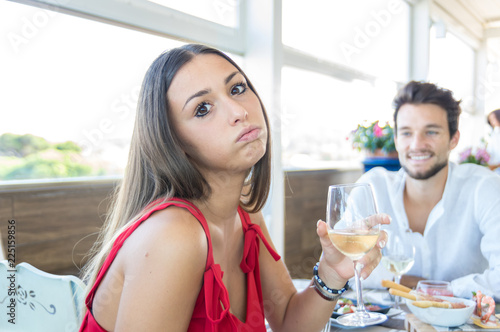 Young woman making an exasperated expression gesture on a bad date at the restaurant © Davide Angelini