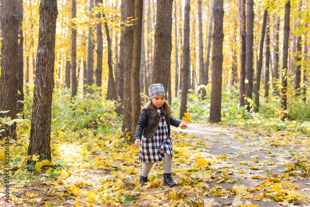 Autumn, seasons and children concept - happy little girl laughing and playing with fallen leaves in park Autumn, seasons and children concept - happy little girl laughing and playing with fallen leaves in park