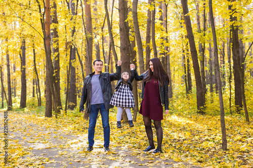 people, family and leisure concept - family with a young daughter walking in autumn park © satura_