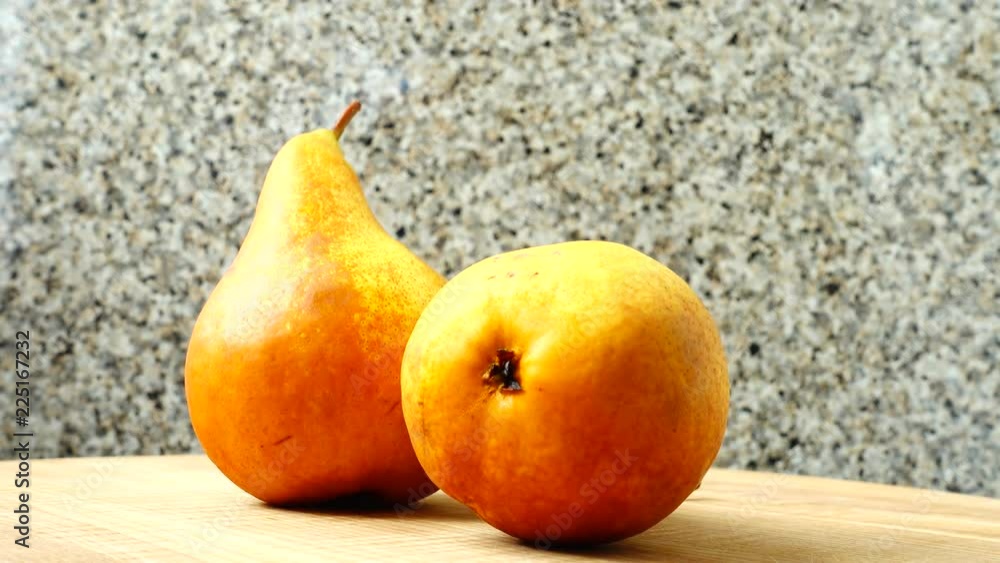Pears on a wooden kitchen board.	Shooting in the movement.