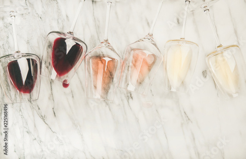 Flat-lay of red, rose and white wine in glasses and corkscrews over grey marble background, top view, copy space. Bojole nouveau, wine bar, winery, wine degustation concept photo