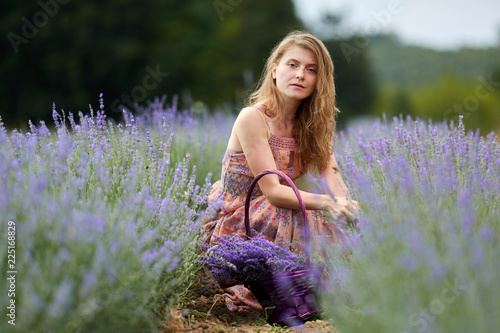 Farmer lady in floral dress in lavender field