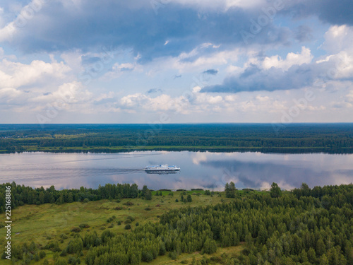 Aerial view of river Volga and cruise ship sailing along. Green riversides and meadows. Summer photo from drone  Russia