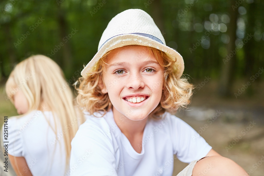 Lächelnder blonder Junge mit Strohhut Lächelnder blonder Junge mit Strohhut