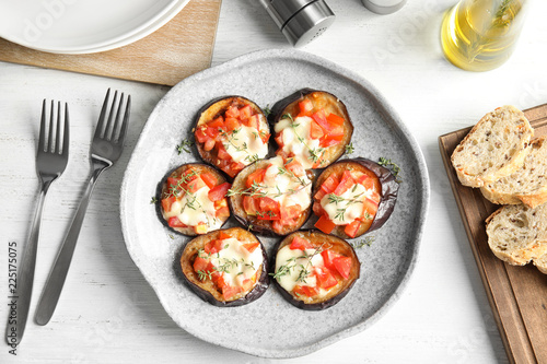 Flat lay composition with baked eggplant, tomatoes and cheese on table