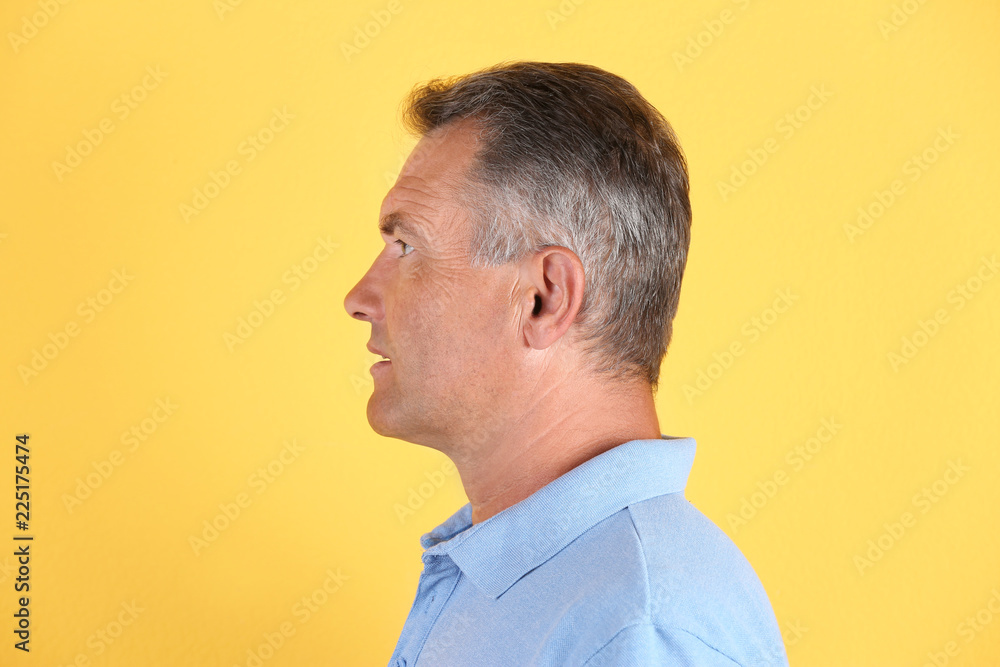 Fototapeta premium Mature man on color background. Hearing problem