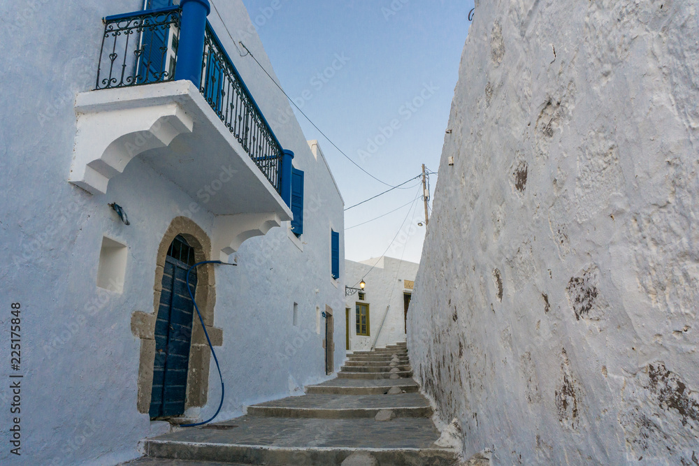 Street view of Plaka picturesque village with paved alleys and traditional houses in Milos island in Cyclades, Greece