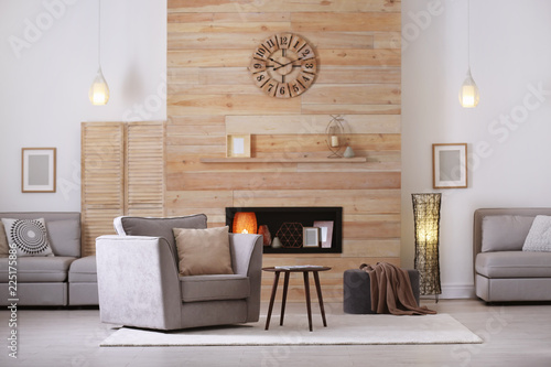Fotografija Cozy furnished apartment with niche in wooden wall and armchair