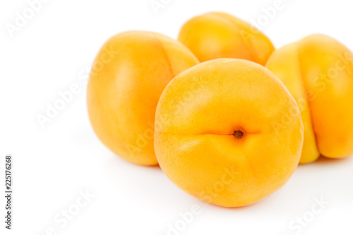 ripe juicy yellow apricots on a white table