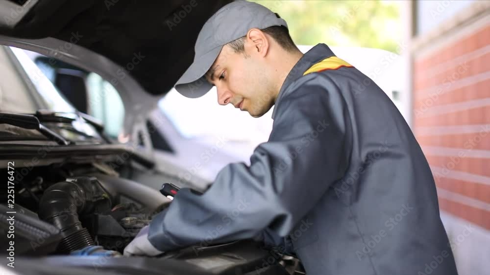 Mechanic checking a truck engine Mechanic checking a truck engine