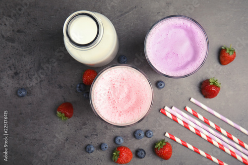 Flat lay composition with delicious milk shakes on grey background