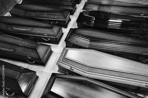 Black and white photo of wooden coffins. Funeral business background