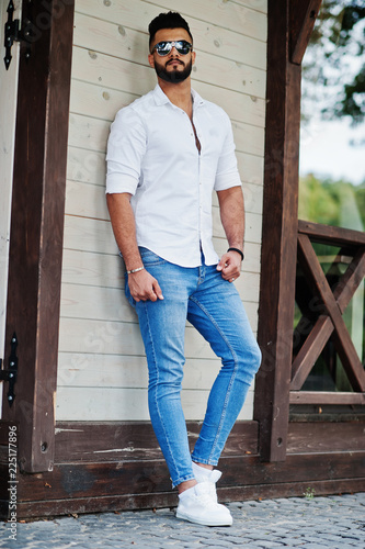 Stockfoto Stylish tall arabian man model in white shirt, jeans and  sunglasses posed at street of city. Beard attractive arab guy. | Adobe Stock