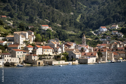 Ancient stone houses in town Vis surrounded with green nature and blue sea, on island Vis in Croatia © Branko