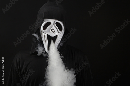 man in a terrible mask and black cloak vape