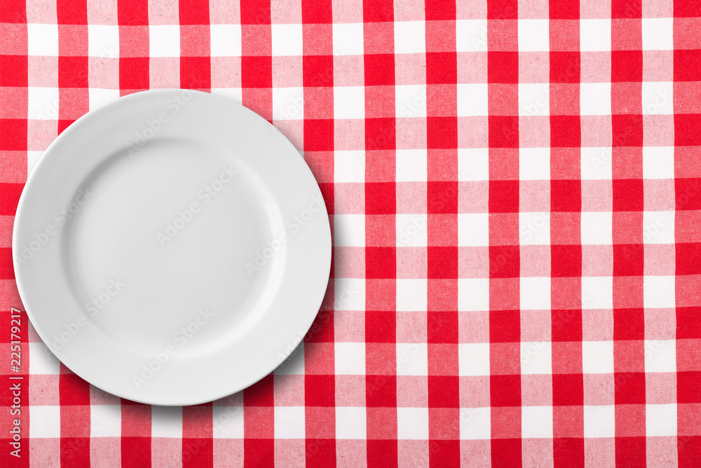empty white plate on red checkered tablecloth empty white plate on red checkered tablecloth