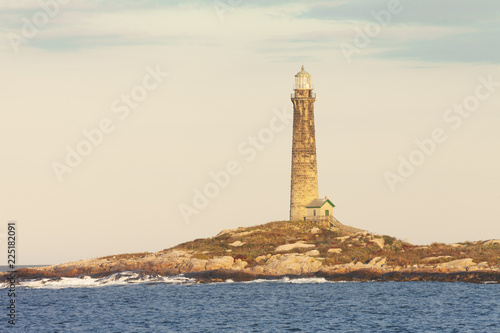 Thacher Island lighthouse lite up by the setting sun on a clear evening © Amy