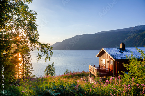 Fotobehang Wooden summerhouse with terrace overlooking scenic lake at sunset in Norway Scan