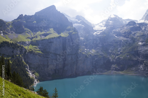 Amazing tourquise Oeschinnensee with waterfalls and Swiss Alps, Kandersteg, Berner Oberland, Switzerland.