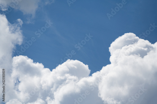 White cumulus clouds against a bright blue sky