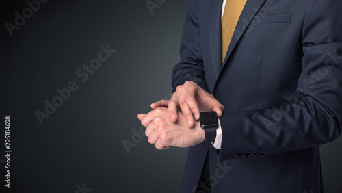 Man wearing suit with smartwatch on his wrist.