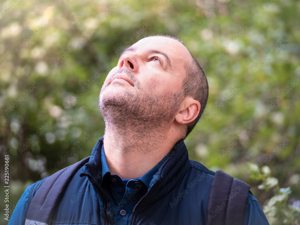 brunette man stands in the forest in nature and looks up brunette man stands in the forest in nature and looks up