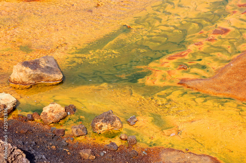 Schilderij op canvas yellow water in a shallow river poisoned by copper production