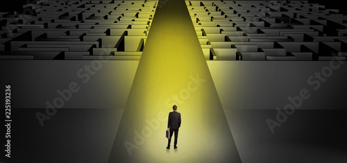 Businessman going straight ahead on a wide road between dark mazes  