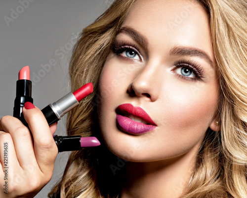BBeautiful woman holds  lipsticks. Makeup.  Beauty concept