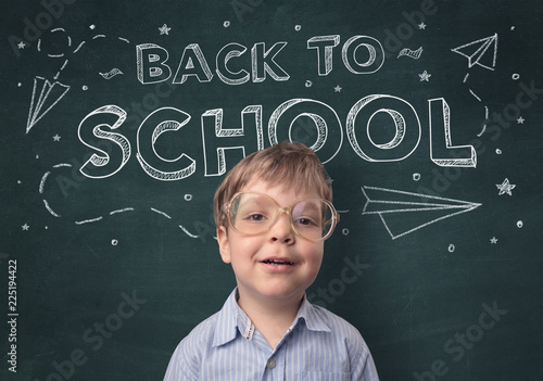 Adorable little boy with blackboard and back to school concept