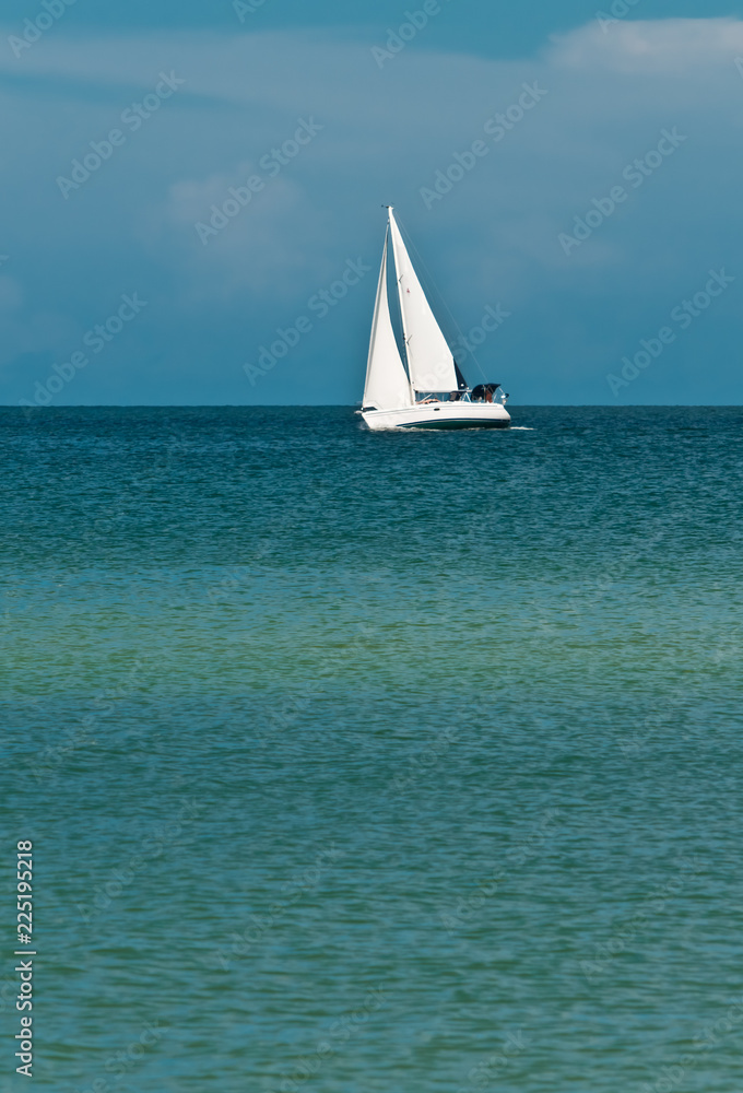 Front view, long distance of a sailing vessel underway from  a strong wind, on an autumn, windy day on the tropical waters of the gulf of mexico