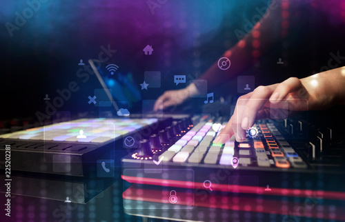 Hand mixing music on dj controller with social media concept icons 