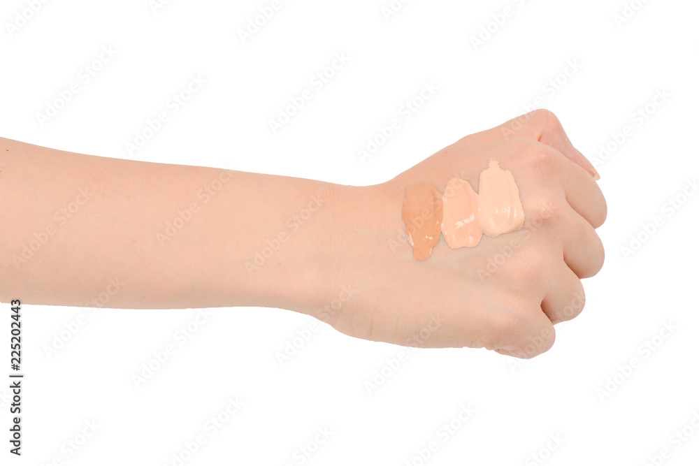 Fair, medium, dark swatches  of foundation on the hand isolated on white.